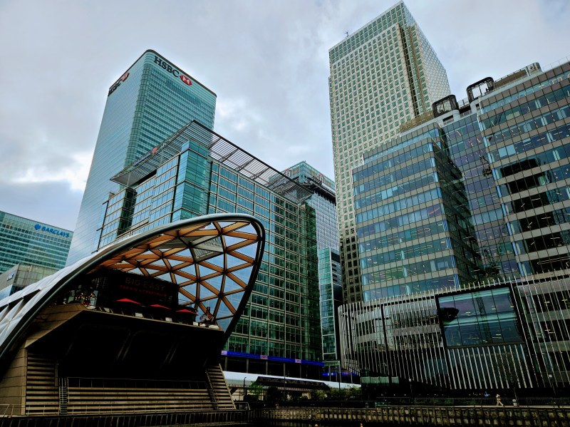 View of modern skyscrapers in Canary Wharf, London, including the HSBC building, with a unique architectural feature in the foreground.