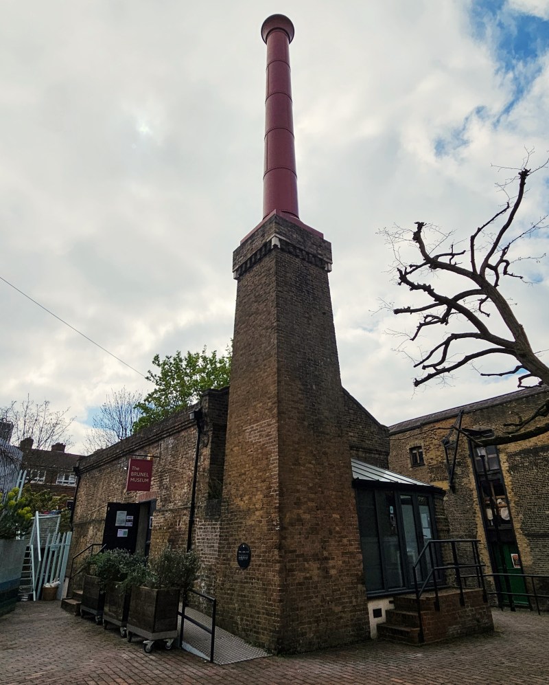 Exterior view of the Brunel Museum showcasing its distinctive red chimney and brick structure under a cloudy sky.